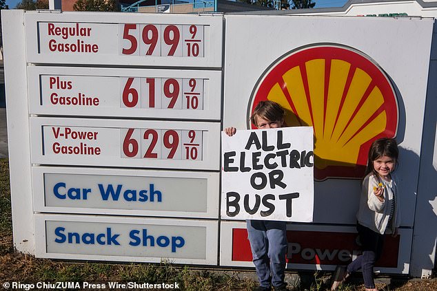 People hold placards protesting against rising gas prices at a Shell Gas Station in Santa Monica, California on Saturday