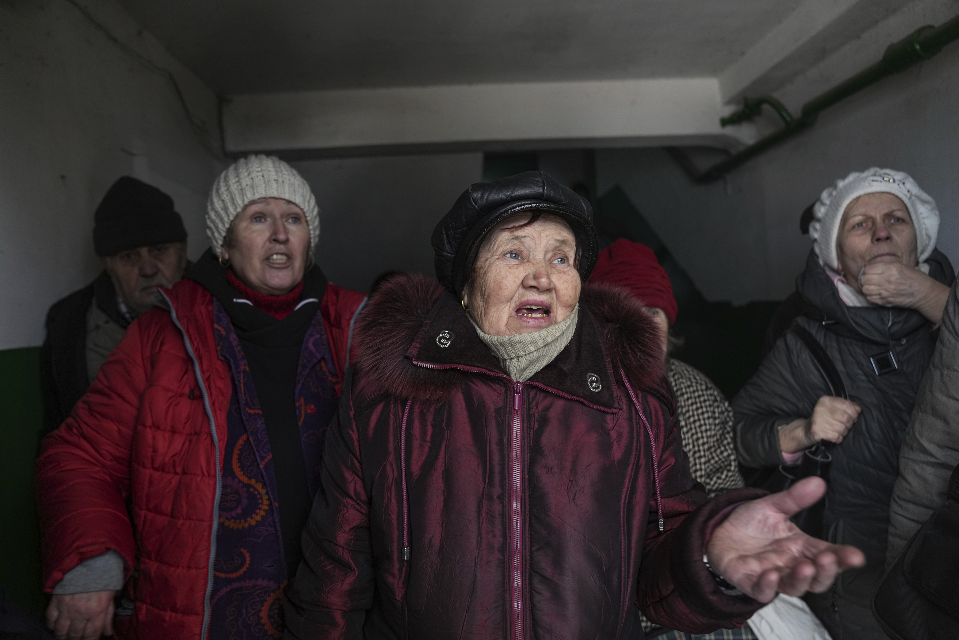 Women talk as they take cover inside the entrance to an apartment building in Mariupol, Ukraine, on March 13.