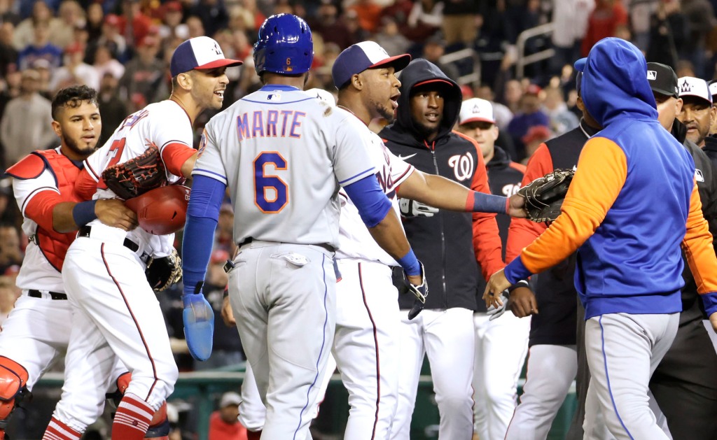 Steve Cheek (left) stopped by Kibert Ruiz after hitting Francisco Lindor causing a Mets and Nationals brawl to take the bench off.