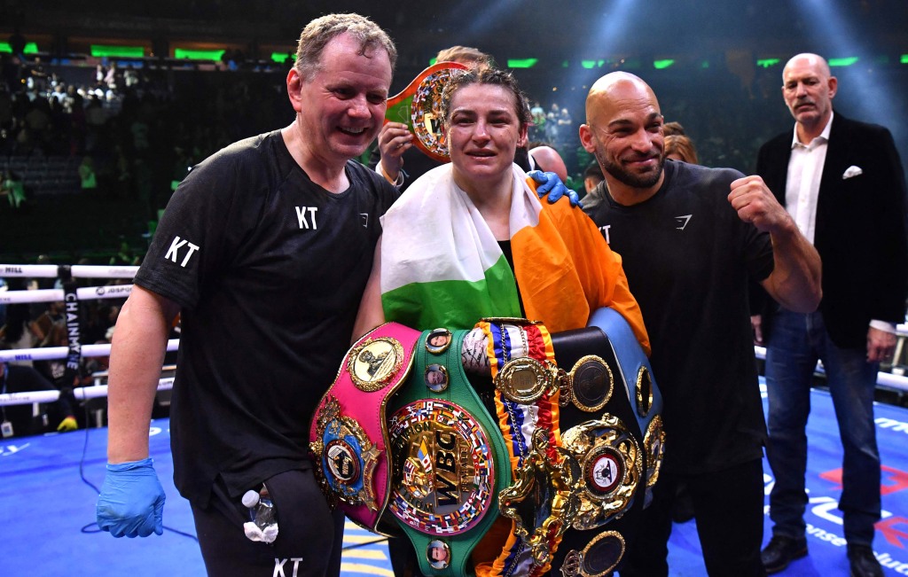 Katie Taylor celebrates alongside coach Brian Peters (left) and coach Ross Inamette after her victory over Amanda Serrano.
