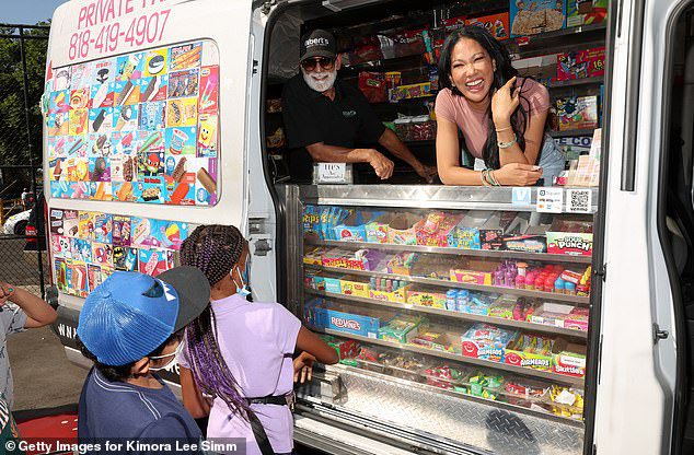 Ice cream anyone?  The model smiled happily as she distributed ice cream to the children who attended the event