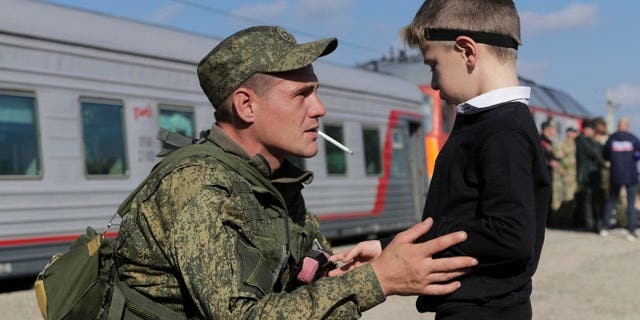 A Russian conscript talks to his son at a railway station in Broadboy, Volgograd region of Russia, on September 29, 2022.