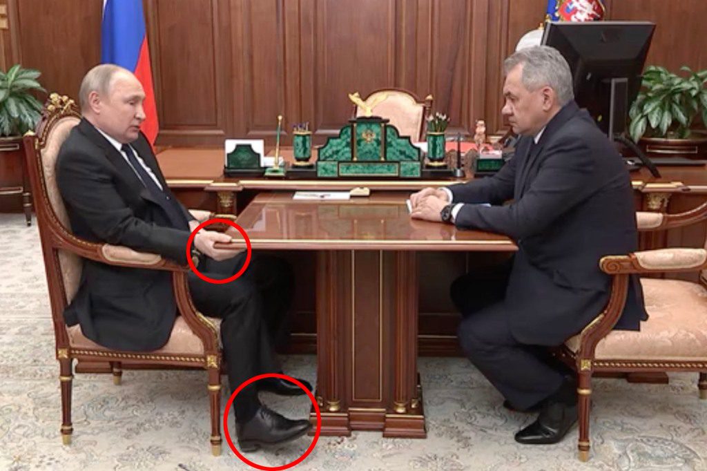 Putin mysteriously grabs the desk during a meeting. 
