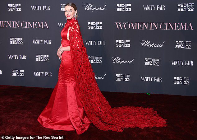 STUNNING CAPE: The red dress featured a long, ruffled cape that flowed down behind her in a long train during a photoshoot on the red carpet