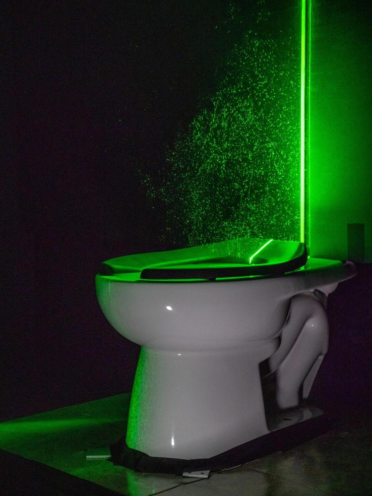 The powerful green laser helps visualize the aerosol plumes from the toilet 